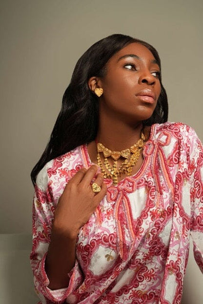 Sirr Eternal heart earring as gold-tone heart stud on model’s left ear, three-quarter portrait view